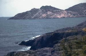 Geologia. Un exemple del triàsic muschelkalk (Tm), a la punta d´en Valls; al fons, Tagomago. Foto: Xavier Guasch Ribas.
