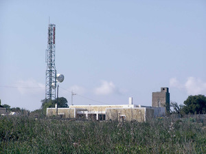 Una altra casa de la zona de sa Talaiassa. A l´esquerra, la torre moderna de comunicacions; a la dreta, la torre militar del 1837, semblant a la des cap de Barbaria. La columna blanca, quadrada, dalt la casa (sa Talaiassa) és el punt geodèsic (196 m, punt més alt de l´illa de Formentera). Foto: Pierre Bayard.